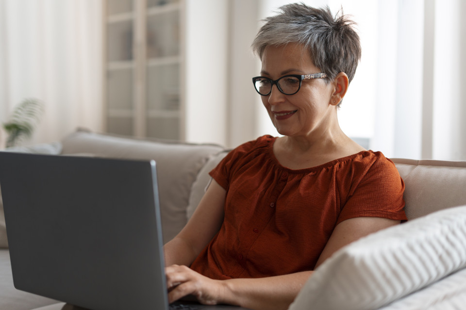 Mujer consultando en su portátil el acceso a la universidad para mayores